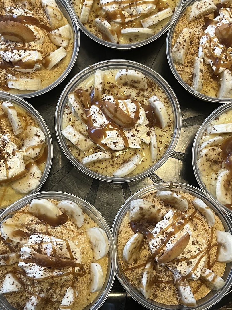 Array of banana pudding cups with caramel drizzle and banana slices, ready for catering