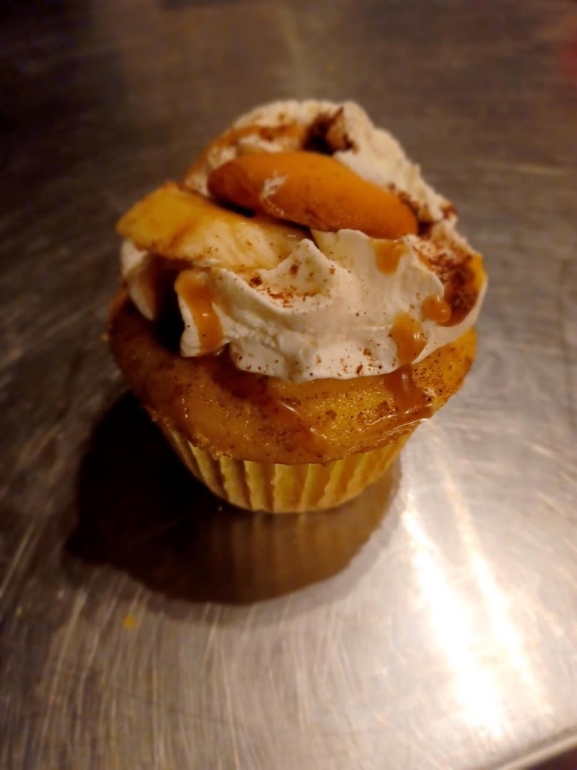 Caramel banana cupcake with whipped cream frosting and cinnamon dusting